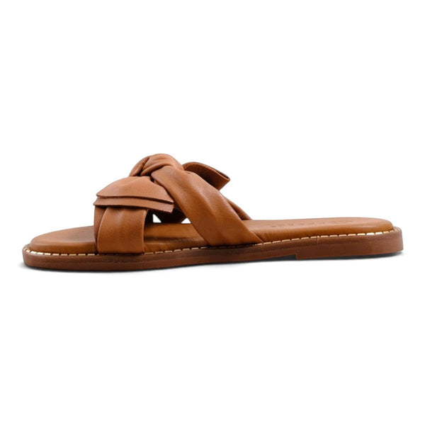 Step Ahead Pesso Bella tan slide sandals featuring a knotted leather strap and flat sole in a side profile view.